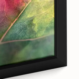Close-up of a black framed canvas featuring textured, colorful floral designs, ideal for living room decor.