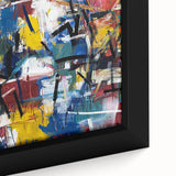 Close-up of a framed abstract canvas featuring vibrant splatter designs in blue, yellow, and red hues, showcasing an artistic blend ideal for modern decor.