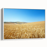 Framed canvas artwork depicting a serene countryside landscape with rolling hills and a vibrant sunset, featuring a white frame that complements the scene. Ideal for home decor.