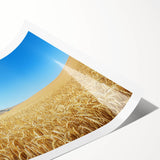 Rolled landscape print showcasing a vibrant countryside scene with lush green fields, a clear blue sky, and distant mountains, securely packaged in a protective tube.