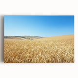 Stretched canvas artwork showcasing a serene countryside landscape, featuring lush green fields, rolling hills, and a vibrant blue sky, ideal for home decor.