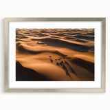 Framed landscape art print showcasing serene sand dunes in soft beige and gold tones, elegantly displayed with a silver mat, perfect for modern home decor.