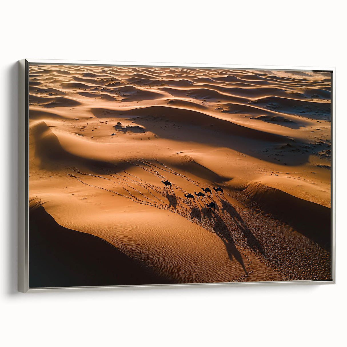 Framed canvas artwork showcasing serene desert dunes in soft beige and gold tones, elegantly presented with a silver frame, ideal for modern home decor.