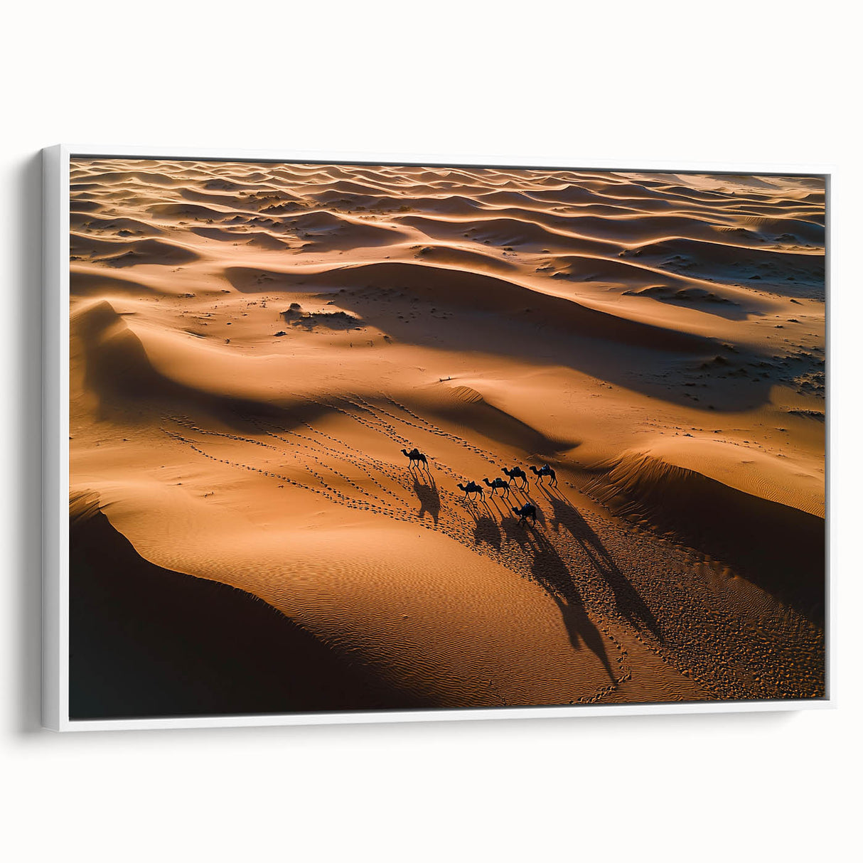 Framed canvas artwork showcasing serene desert dunes in soft beige and gold tones, set against a minimalist white frame for a modern decor touch.