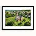 Elegant black-framed landscape artwork showcasing a majestic castle surrounded by lush greenery, presented with a mat for a refined finish. Perfect for home decor.