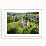 Elegant white-framed landscape artwork featuring a picturesque castle surrounded by lush greenery, ideal for home decor. The mat adds a sophisticated touch to the presentation, enhancing the visual appeal of the scenic view. Perfect for adding charm to living spaces.