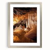 Framed landscape artwork showcasing a stunning cave scene, featuring intricate details and a silver matting, perfect for home decor or gallery display.