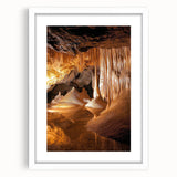 Framed landscape artwork featuring a serene cave scene with rich earth tones, complemented by a white mat, perfect for home decor and artistic expression.
