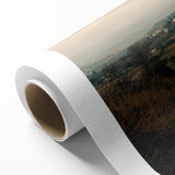 Rolled canvas artwork depicting a serene countryside landscape, showcasing vibrant green fields and a clear blue sky, securely packaged in a durable cardboard tube.