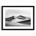 Framed landscape art print depicting serene sand dunes in a minimalist black frame, accented with a white mat, perfect for modern home decor.