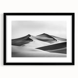 Framed landscape art print depicting serene sand dunes in a minimalist black frame, accented with a white mat, perfect for modern home decor.