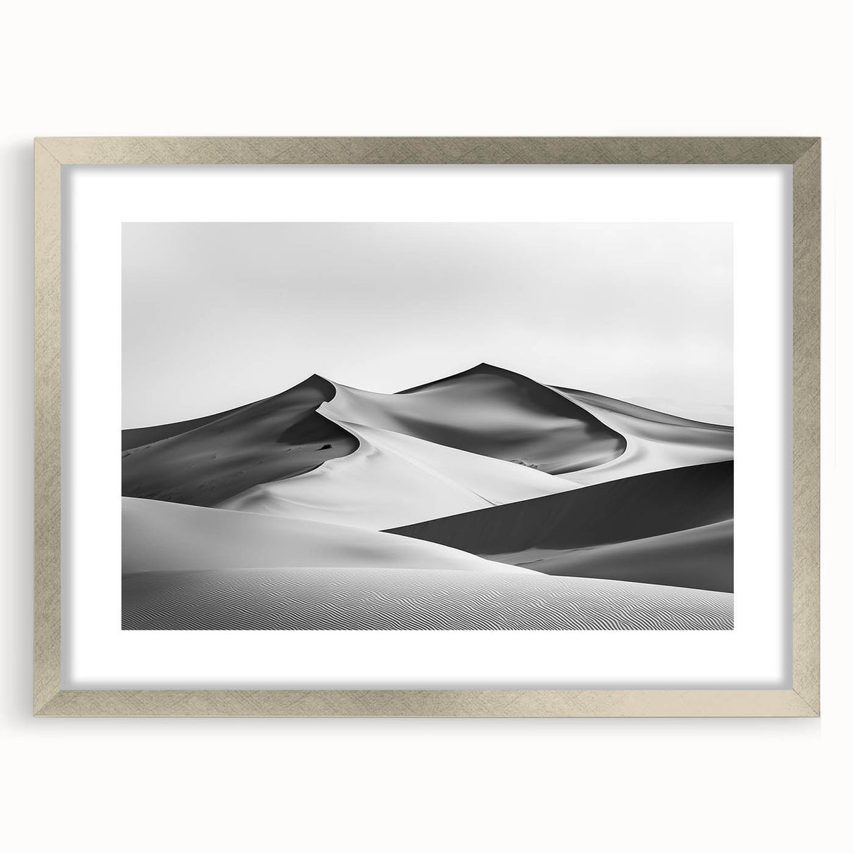 Framed landscape art print showcasing serene sand dunes in soft beige and gold tones, surrounded by a sleek silver mat, perfect for modern home decor.