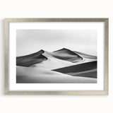 Framed landscape art print showcasing serene sand dunes in soft beige and gold tones, surrounded by a sleek silver mat, perfect for modern home decor.
