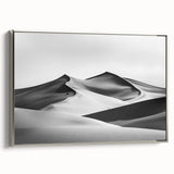 Framed canvas artwork depicting serene sand dunes under a soft sunset glow, featuring a silver frame. Perfect for enhancing modern home decor with a touch of nature.