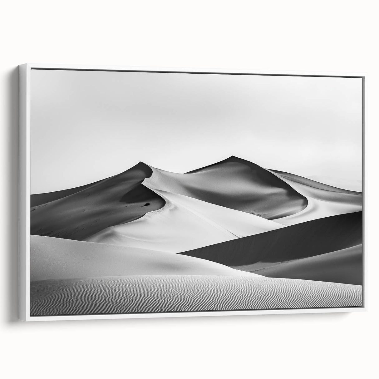 Framed canvas art depicting serene sand dunes in soft beige and golden hues, showcasing a white frame that enhances the landscape's tranquility, perfect for home decor.