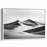 Framed canvas art depicting serene sand dunes in soft beige and golden hues, showcasing a white frame that enhances the landscape's tranquility, perfect for home decor.