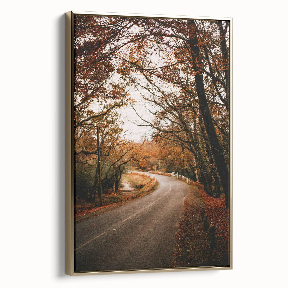 Framed canvas featuring a vintage-style landscape painting of an autumnal scene with muted gold and black tones.