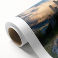 Rolled canvas showcasing a vibrant landscape of a majestic castle, featuring lush greenery and a clear blue sky, elegantly packaged in a protective cardboard tube for delivery.