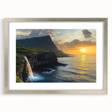 Framed landscape artwork depicting dramatic cliffs under a vibrant sunset, set in a sleek silver frame with a white mat, ideal for enhancing modern decor.