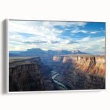 Framed canvas artwork showcasing a stunning landscape of canyons, featuring vibrant colors and intricate details, displayed in a white frame for an elegant touch.