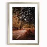 Textured abstract art print depicting fall themes in warm orange and brown tones, framed in silver.