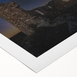 Rolled canvas artwork depicting a serene landscape with a majestic castle set against a vibrant sunset. Ideal for home decor, showcasing intricate details and rich colors.