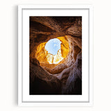 Framed landscape artwork depicting a serene cave scene, featuring earthy tones and intricate details, presented with a white mat for a polished look. Ideal for enhancing home decor.