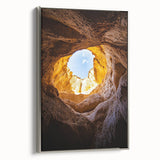 Framed canvas artwork depicting a serene landscape scene with caves, featuring a silver frame, perfect for home decor. Ideal for nature lovers and art enthusiasts.