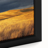 Close-up of a framed canvas artwork depicting a serene countryside landscape, showcasing lush green fields, rolling hills, and a bright blue sky, perfect for home decor.