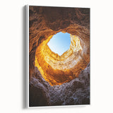 Framed canvas artwork depicting a serene landscape of caves, featuring earthy tones and intricate details, set against a white background for a modern touch.