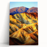 Stretched canvas artwork showcasing a vibrant desert landscape with warm hues of orange and yellow, elegantly leaning against a neutral wall, perfect for home decor.