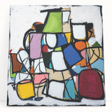 Abstract geometric design canvas artwork in vibrant blue, orange, and yellow hues, leaning against a light-colored wall, perfect for modern home decor.