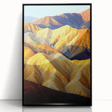 Framed acrylic artwork showcasing a vibrant desert landscape with warm tones of orange and yellow, set in a sleek black frame. Ideal for modern home decor.