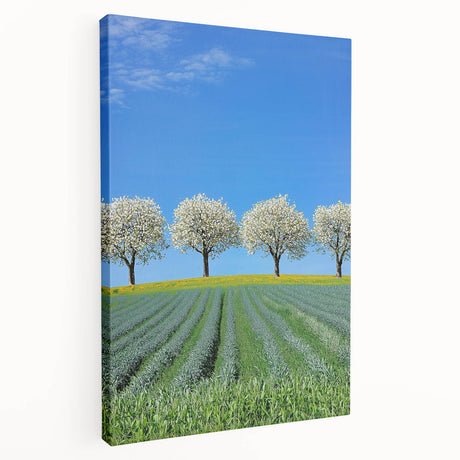 Stretched canvas artwork depicting a vibrant landscape with rolling fields under a bright blue sky, showcasing rich greens and warm earth tones, ideal for home decor.