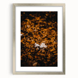 Textured abstract art print depicting autumnal hues in a silver frame, ideal for bedroom wall decor.