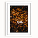 Abstract art print featuring swirling autumn hues on a white framed canvas, suitable for bedroom or dining room decor.