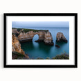 Black-framed landscape artwork showcasing dramatic cliffs and vibrant skies, presented with a white mat for an elegant finish, ideal for home decor.