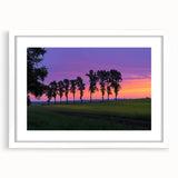 Framed countryside landscape artwork in a white mat, showcasing vibrant green fields and a serene blue sky, perfect for home decor or office settings.