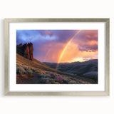 Framed landscape artwork depicting a serene desert scene with vibrant hues of orange and gold, elegantly presented in a silver frame with a mat for added refinement.