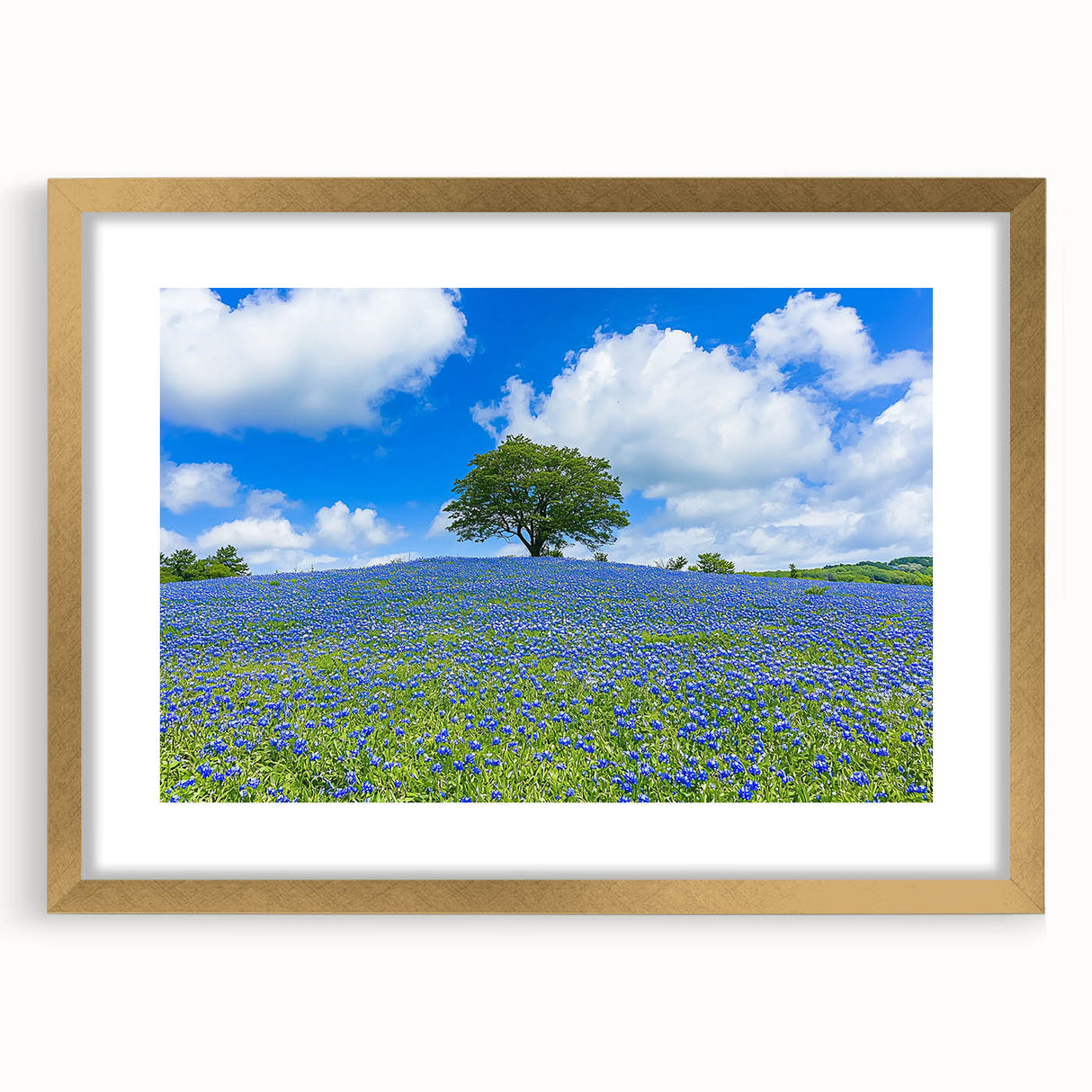Elegant gold-framed landscape artwork featuring vibrant green fields and a serene sky, designed with a decorative mat for an upscale home decor touch.