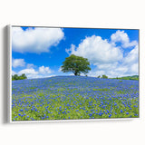 Framed canvas artwork showcasing a serene landscape scene with lush green fields and a blue sky, presented in a sleek white frame, ideal for home decor.