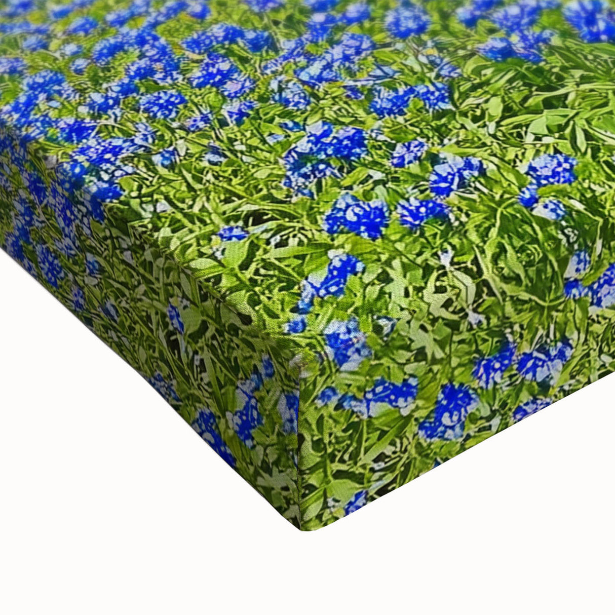 Close-up of a vibrant stretched canvas artwork depicting a serene landscape with lush green fields under a clear blue sky, perfect for home decor.