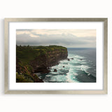 Elegant silver-framed landscape print showcasing dramatic cliffs and serene skies, accented by a textured mat, ideal for enhancing home decor with nature's beauty.