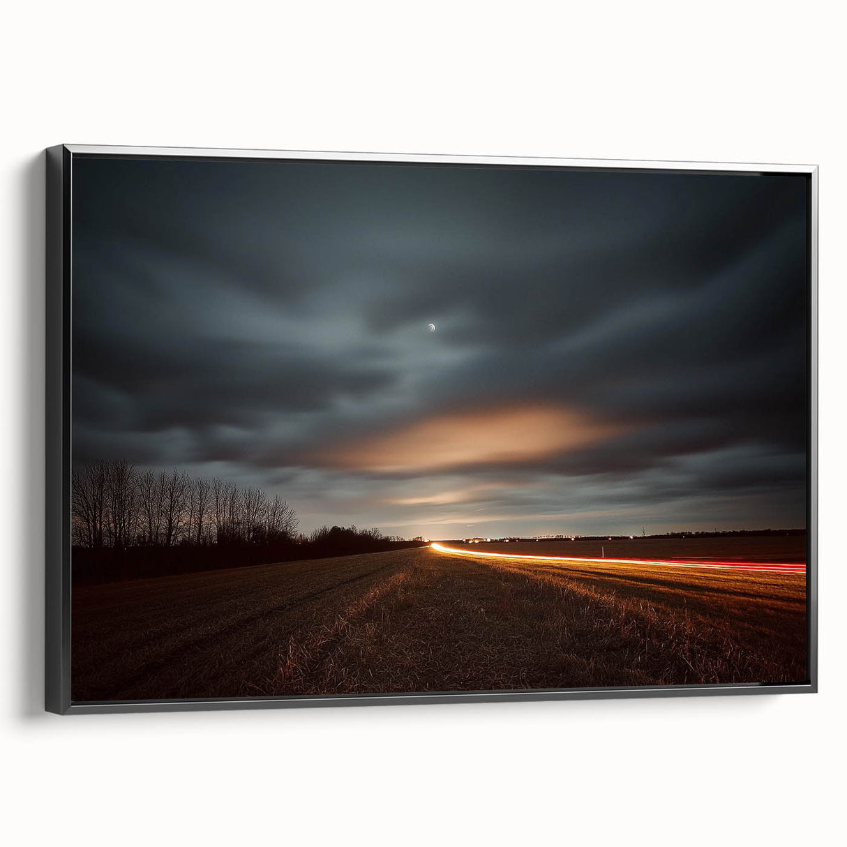 Framed canvas artwork depicting a serene countryside landscape with lush green fields, vibrant blue sky, and rustic charm, presented in a sleek black frame for modern decor.