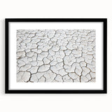 Black-framed landscape artwork depicting a serene desert scene, featuring warm earth tones and intricate details, ideal for home decor or office aesthetics.