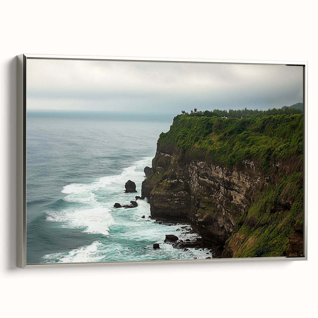 Framed canvas artwork depicting a stunning landscape with dramatic cliffs and vibrant colors, featuring a sleek silver frame that enhances its modern aesthetic.