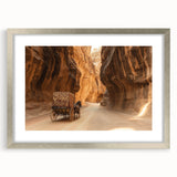 Framed landscape artwork depicting vibrant canyons in rich earthy tones, showcased in a sleek silver frame with a classic white mat. Ideal for home decor.