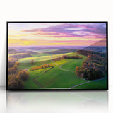 Framed acrylic artwork showcasing a serene countryside landscape, featuring lush green fields and a clear blue sky, presented in a sleek black frame for modern decor.