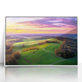 Framed acrylic landscape artwork depicting a serene countryside scene with vibrant greens and soft blues, set in a sleek white frame, ideal for home decor.