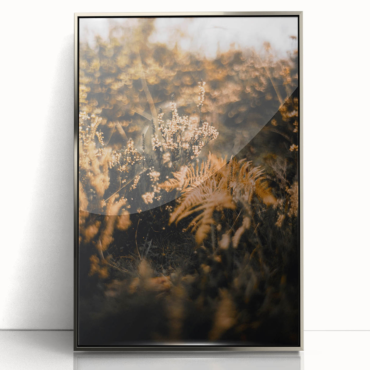Mid-century modernist art depicting fall trees in muted orange and brown tones, framed in silver acrylic.